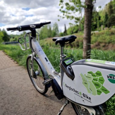 Das Bild zeigt ein Bergisches E-Bike, das auf dem Weg entlang der Sülz steht.