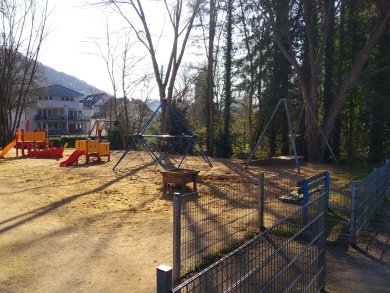 Spielplatz Hoffnungsthal an der Sülz Zu sehen ist eine große Sandfläche mit mehreren Spielgeräten.