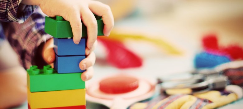 Symbolbild Kita Das Bild zeigt ein spielendes Kind mit Bausteinen.