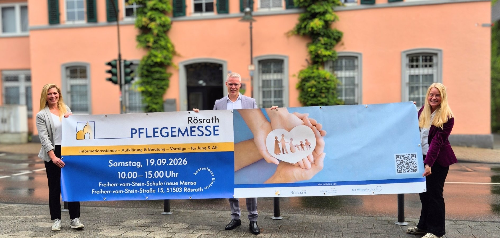 Mit einem Banner vorm Rathaus wird die zweite Auflage der Rösrather Pflegemesse angekündigt.