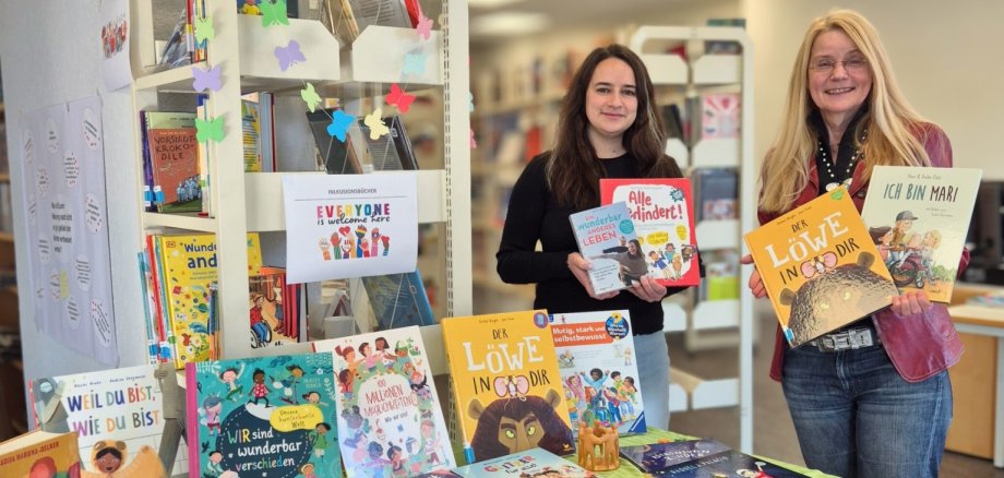 Das Bild zeigt Büchereileiterin Carolyn Bauke und Inklusionsbeauftragte Elke Günzel in der Stadtbücherei.