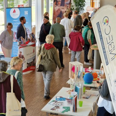 Das Bild zeigt ein Blick in den gut besuchten Ausstellungsraum der Rösrather Pflegemesse 2024.