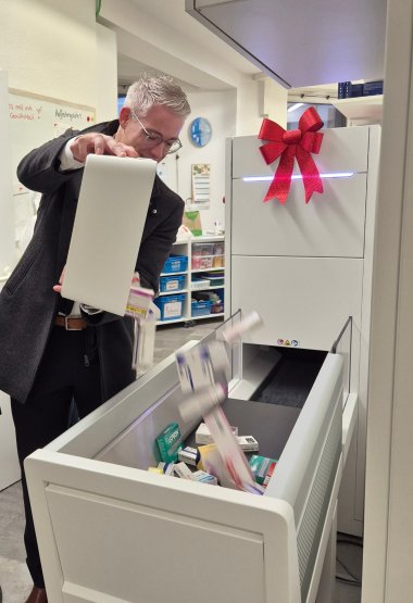 Bürgermeister testet das automatisierte Lagersystem. Bürgermeister Yannick Steinbach testet das neue Lagersystem, das bis zu 300 Medikamentenpackungen pro Stunde vollautomatisch sortiert und einlagert.