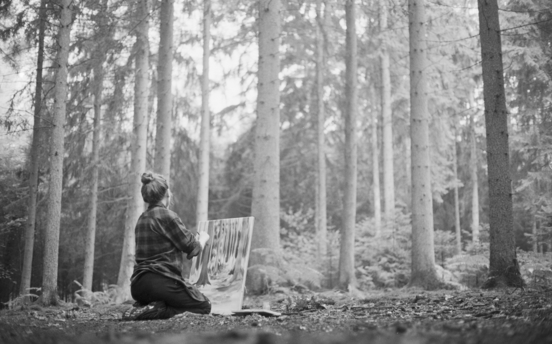Das Bild zeigt Lukrezia Krämer im Rösrather Wald mit einer Staffelei beim Malen eines Bildes.