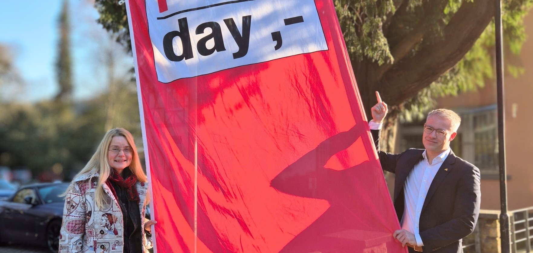 Bürgermeister und Gleichstellungsbeauftragte zeigen Flagge zum Equal Pay Day.