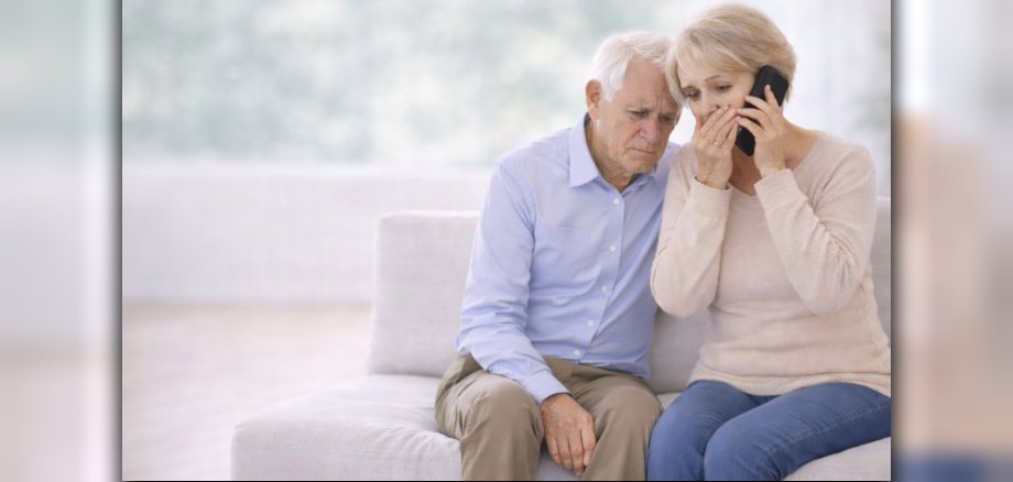 Das Bild zeigt ein besorgtes Seniorenpaar am Telefon.